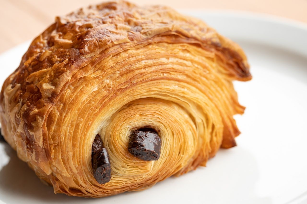 Um close de um croissant de chocolate em um prato branco