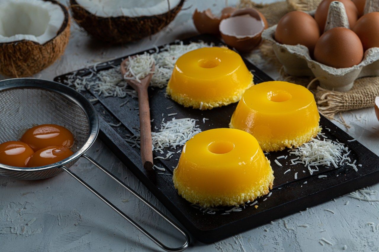 Um close de uma bandeja de comida com ovos e coco em uma mesa.