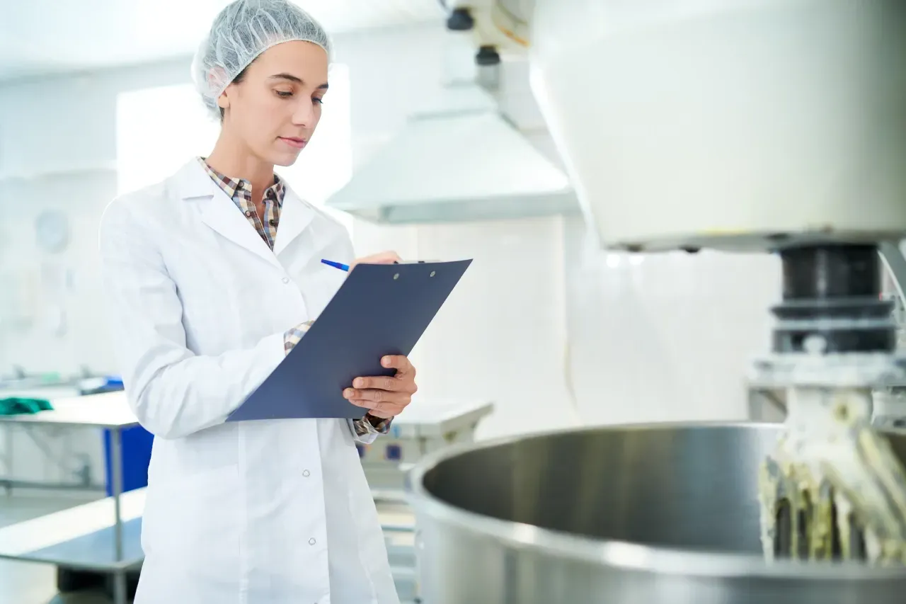 nutricionista fazendo a inspeção dos equipamentos em um ambiente de preparo de alimentos