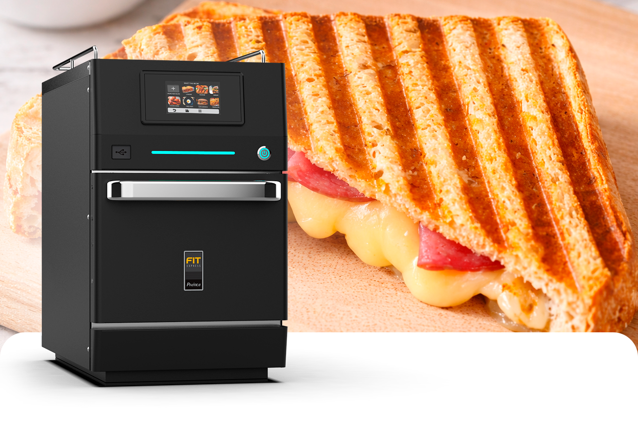 Um sanduíche está sobre uma mesa ao lado de uma torradeira.