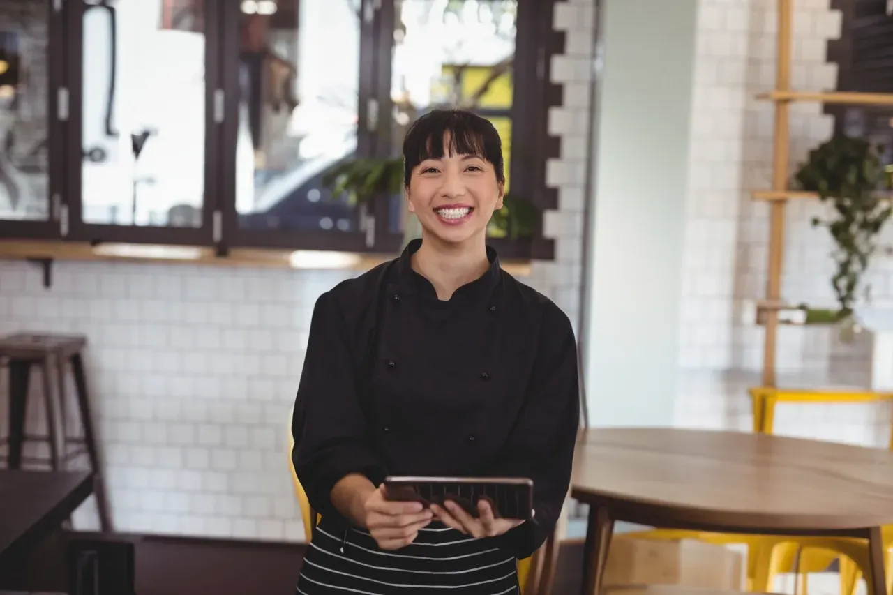 colaboradora feliz uniformizada em um restaurante