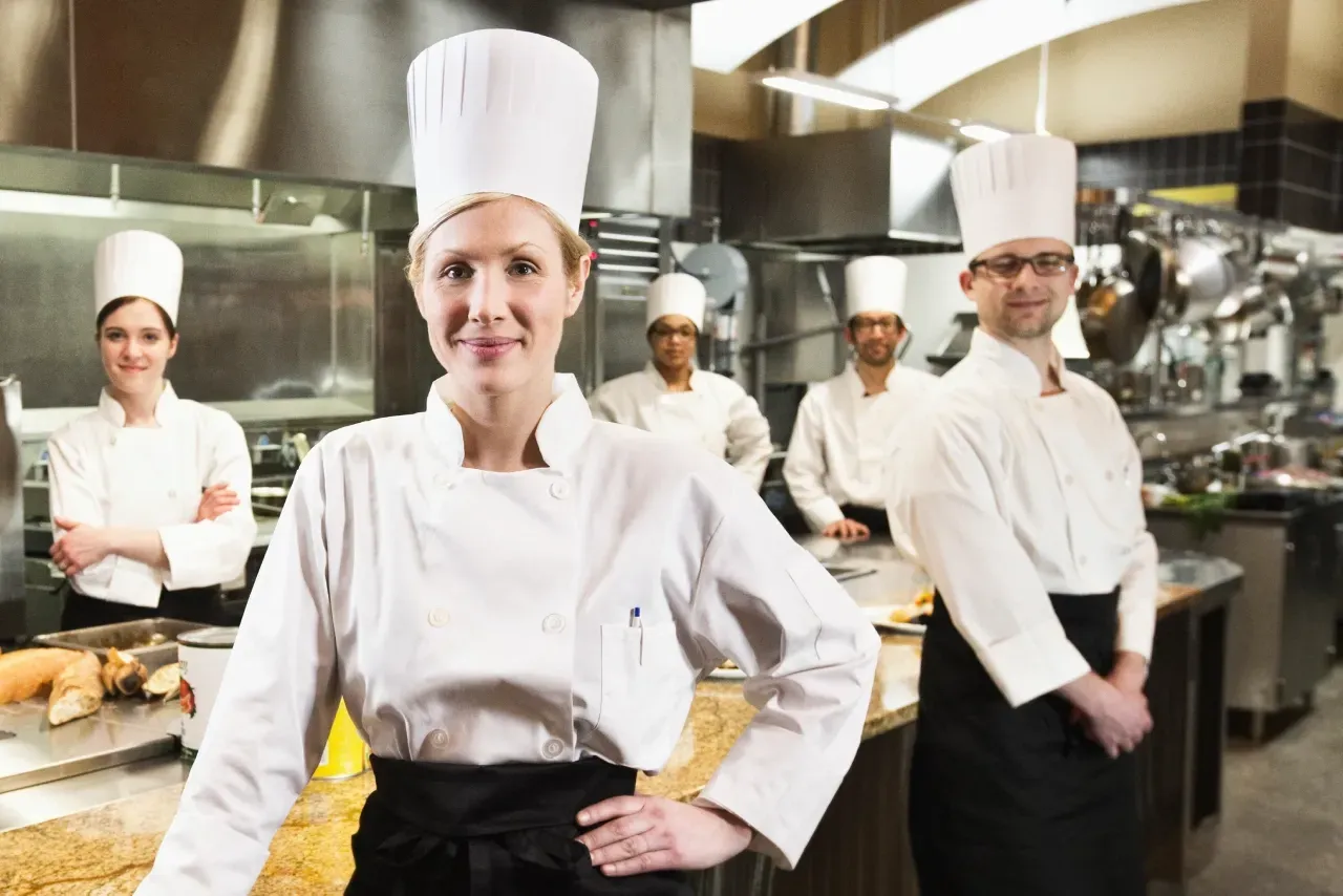 equipe de cozinha com uniformes brancos em uma cozinha profissional