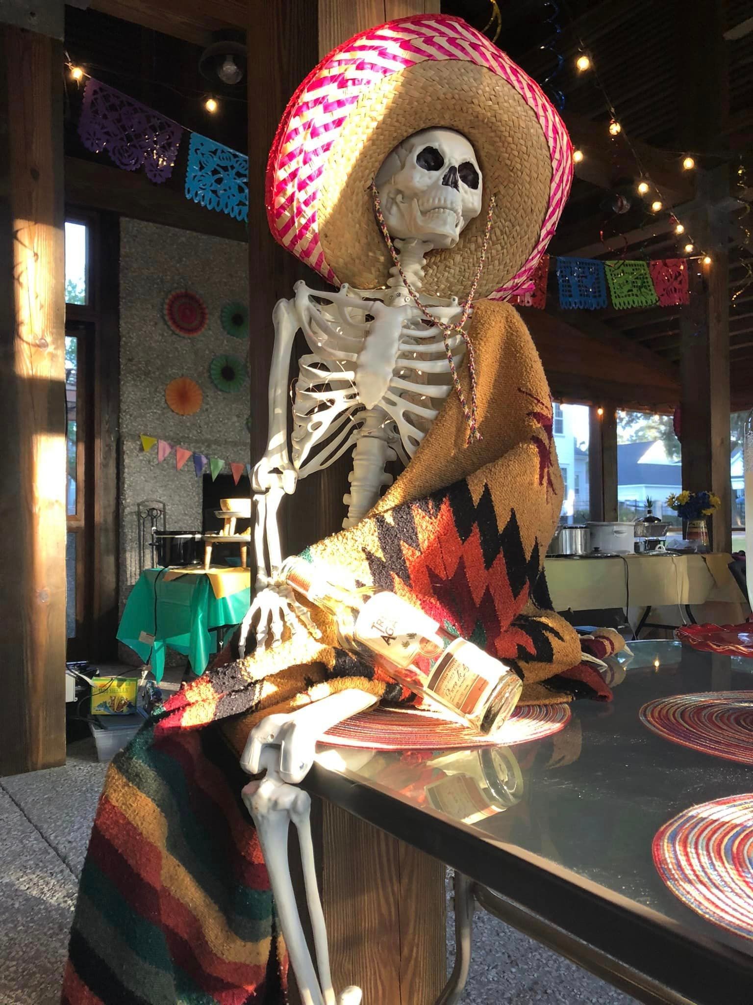Cinco de Mayo party skeleton with a sombrero, mexican blanket and a bottle of alcohol