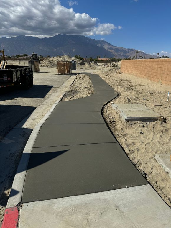 A concrete walkway with mountains in the background