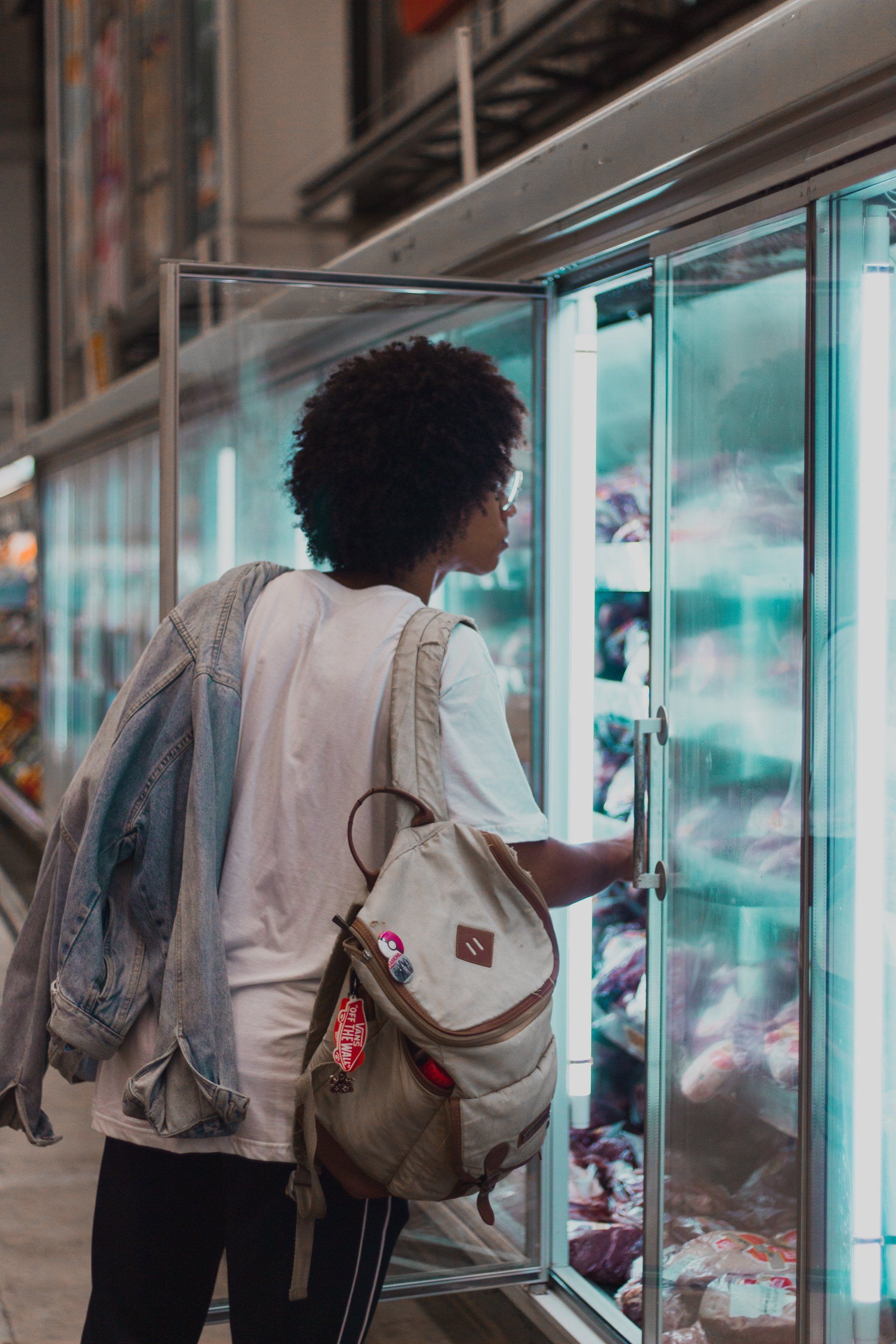 a woman is standing in front of a refrigerator in a grocery store. Supermarket Rack Refrigeration