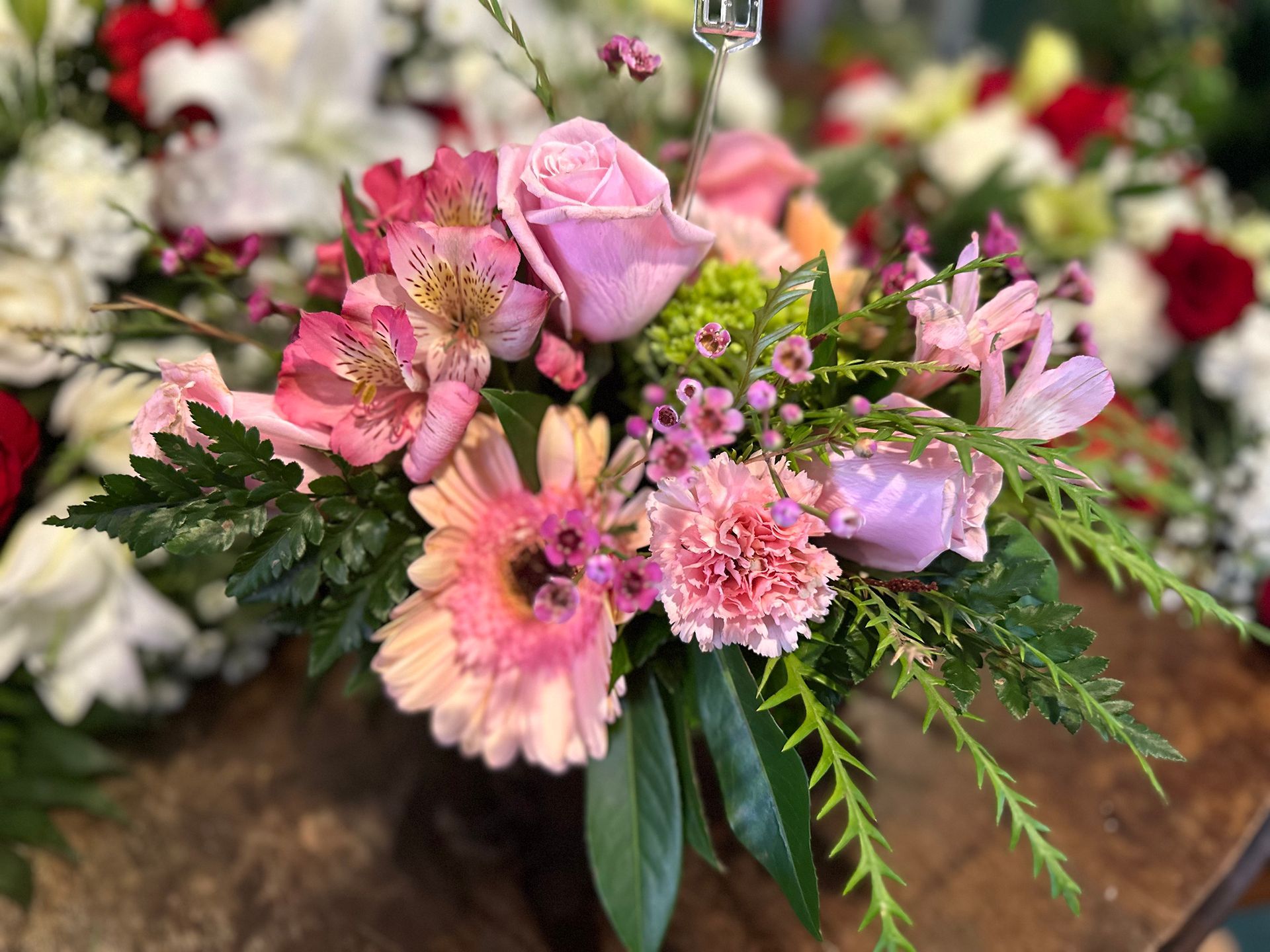 Arrangement of pink and peach flowers with green foliage, close-up.