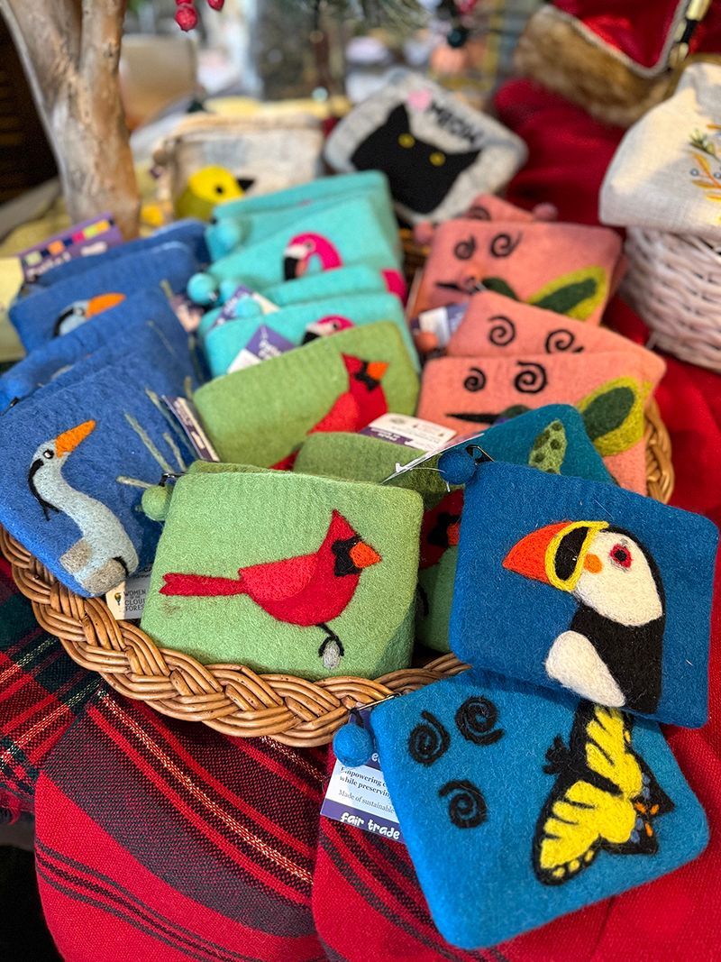 Wicker basket overflowing with colorful, embroidered coin purses, each with a different animal design.