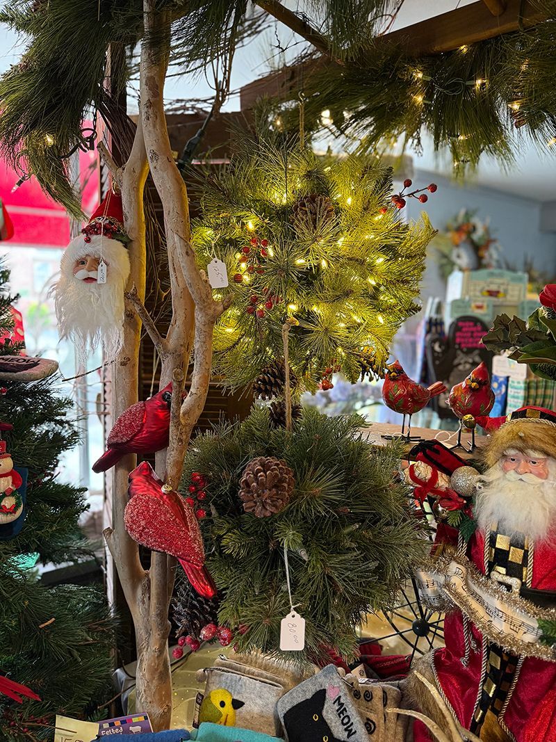 A vase filled with flowers and a wooden bunny on a table.