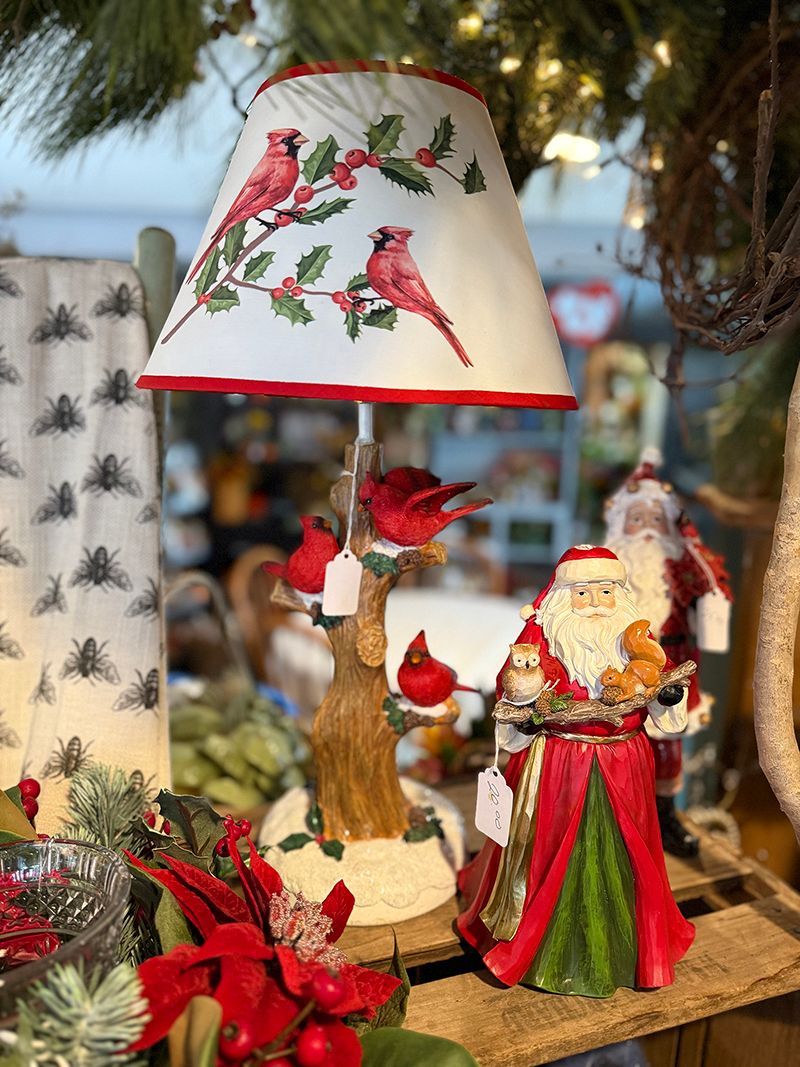 Lamp with cardinal design, Santa figurine, and Christmas decorations.