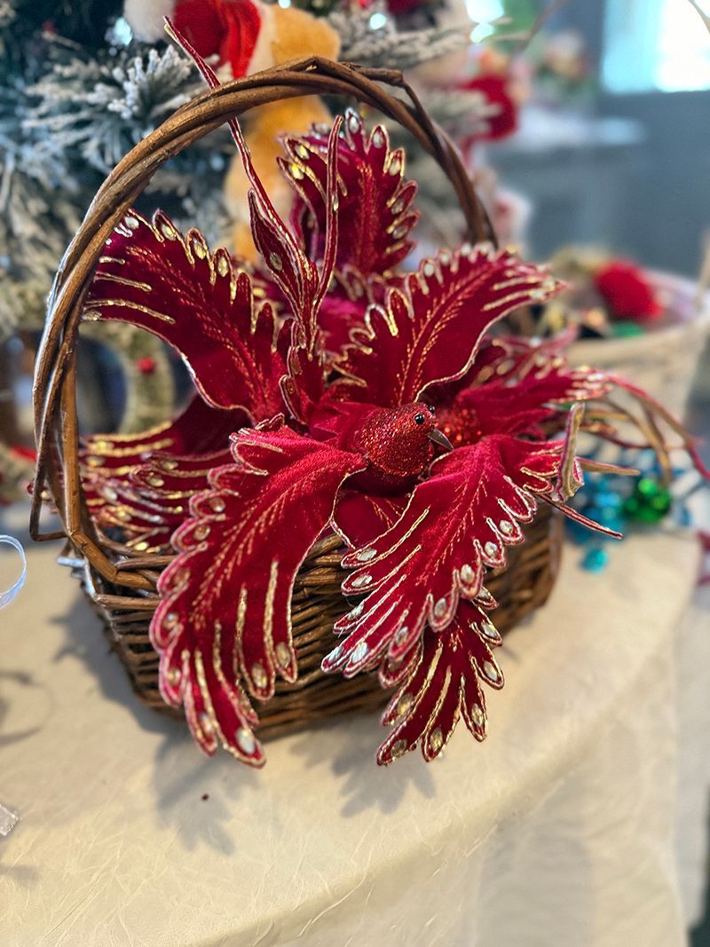 Red and gold decorative floral arrangement in a woven basket.