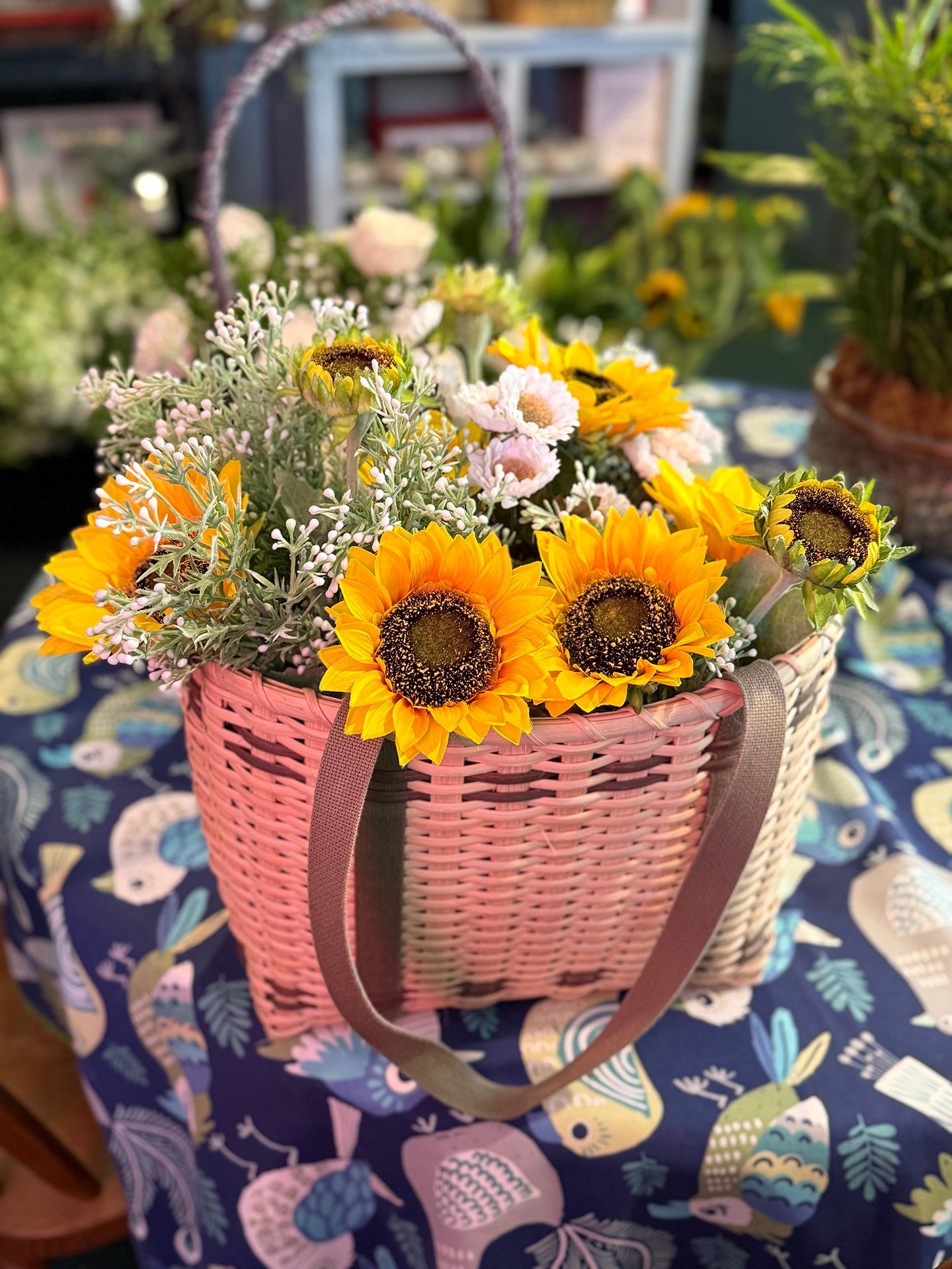 A vase filled with flowers and a wooden bunny on a table.