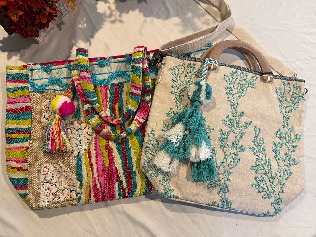 Two green vases filled with succulents are sitting on a table next to a bicycle.