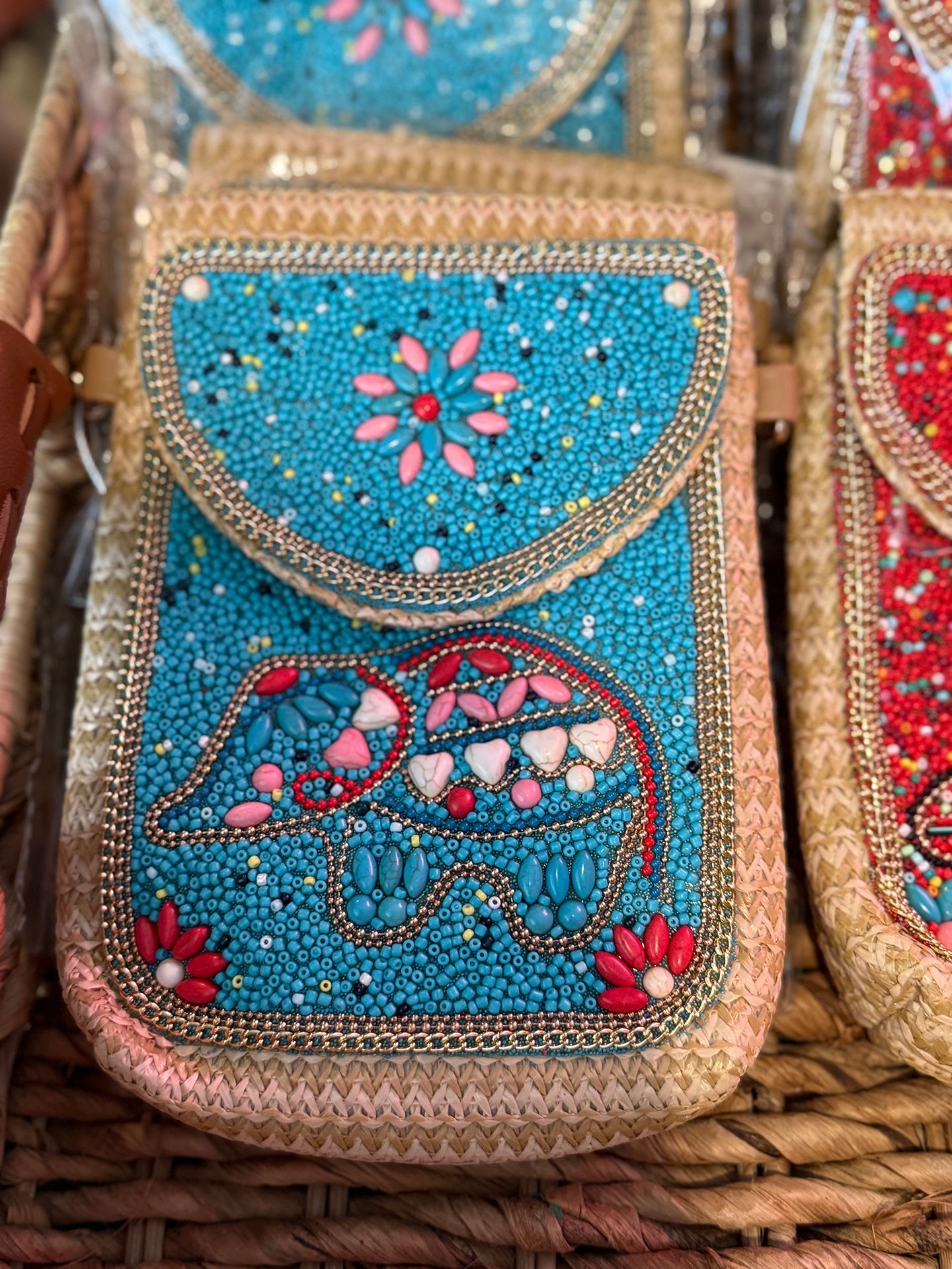Blue beaded cell phone bag with elephant design and flower embellishments.