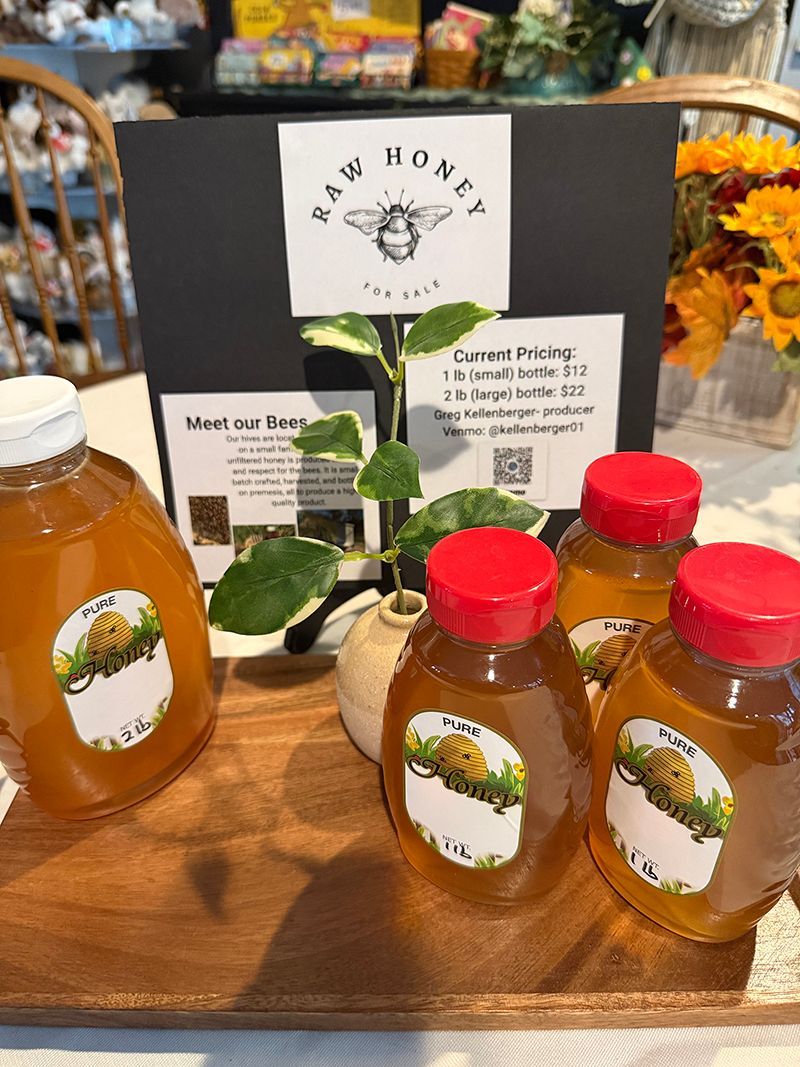 A close up of an orange orchid in a pot on a brick floor.