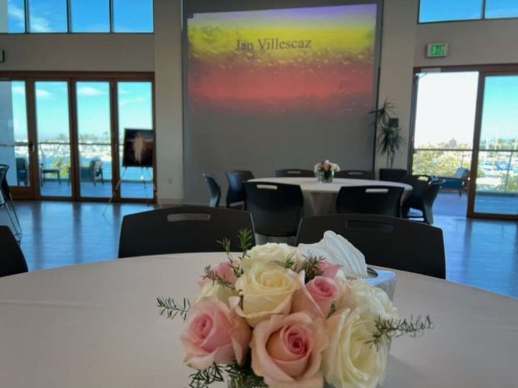 Celebration of Life Event Setup with Projection Screen, Seating, and Floral Arrangement, with Professional AV Support in Colorado Springs, Denver, and Pueblo.