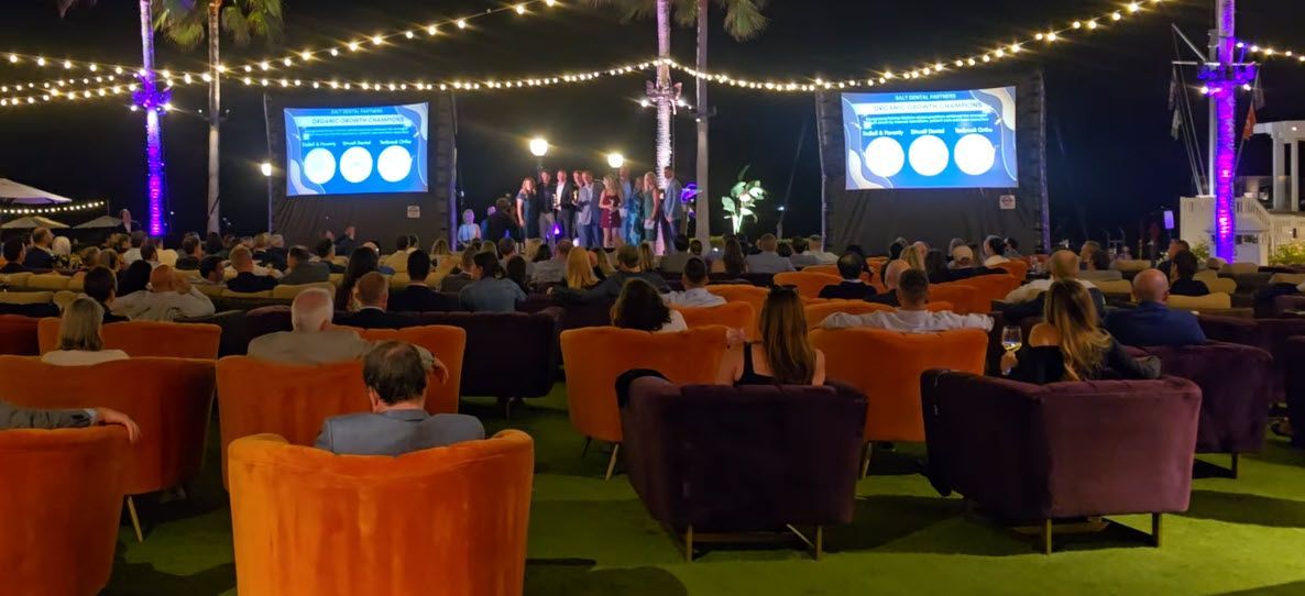 Evening Outdoor Presentation Setup with Inflatable Screens and String Lights for Meetings under 200 People