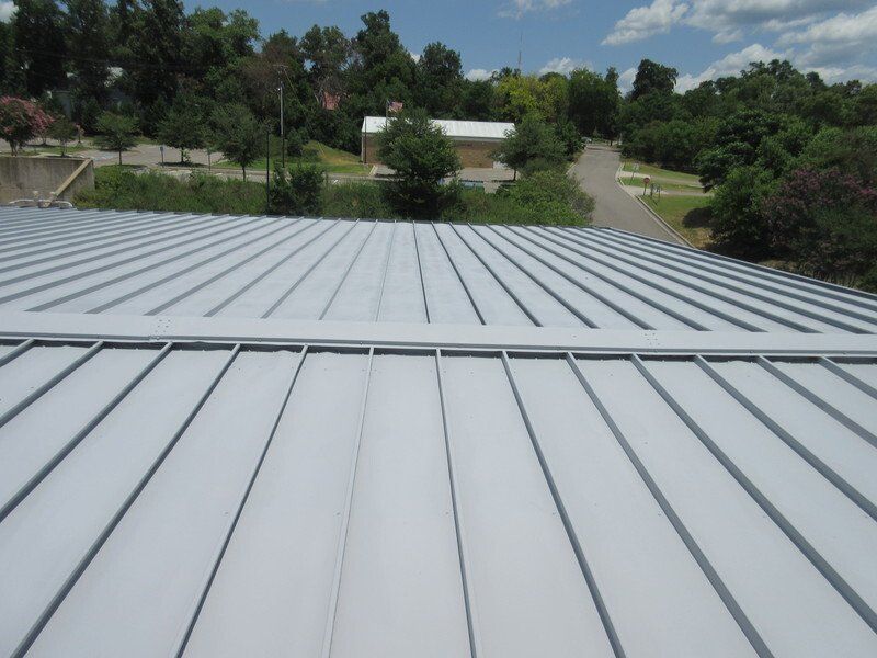 A white roof with a few trees in the background