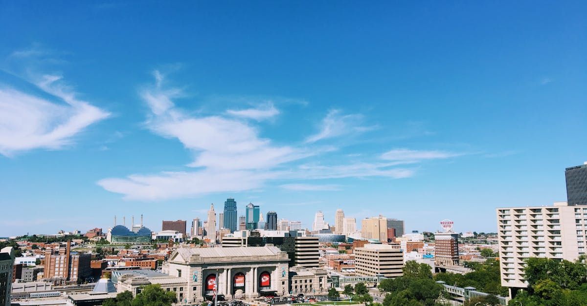 A large lobby in a modern office building with a reception desk , chairs , tables and plants.
