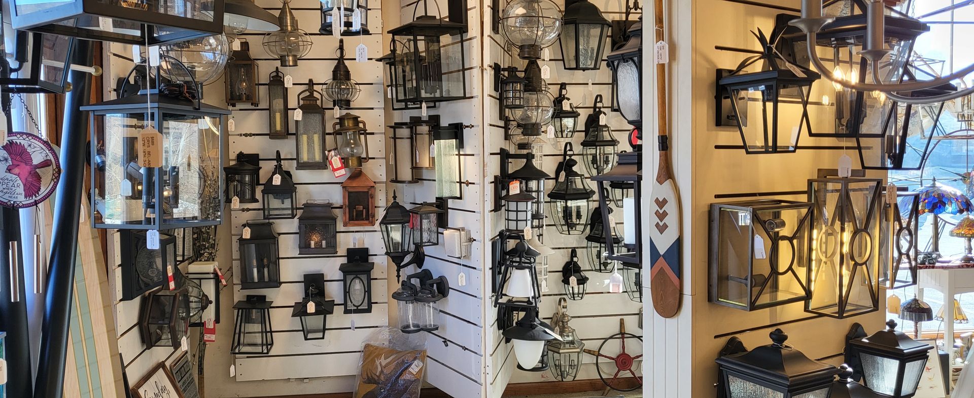 There are many different types of lanterns hanging on the wall.