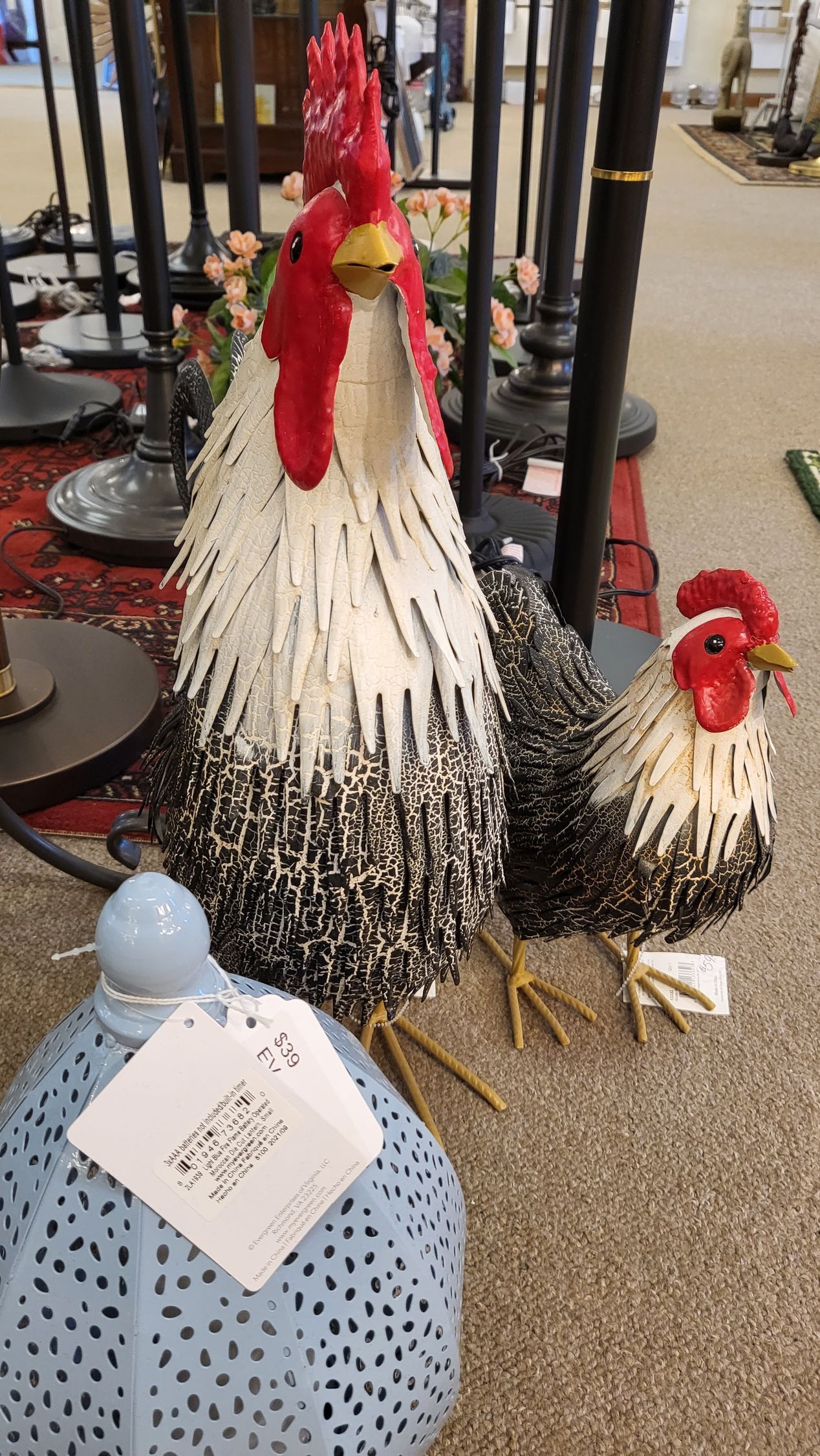 Three roosters are sitting next to each other on the floor in a room. Avon, CT