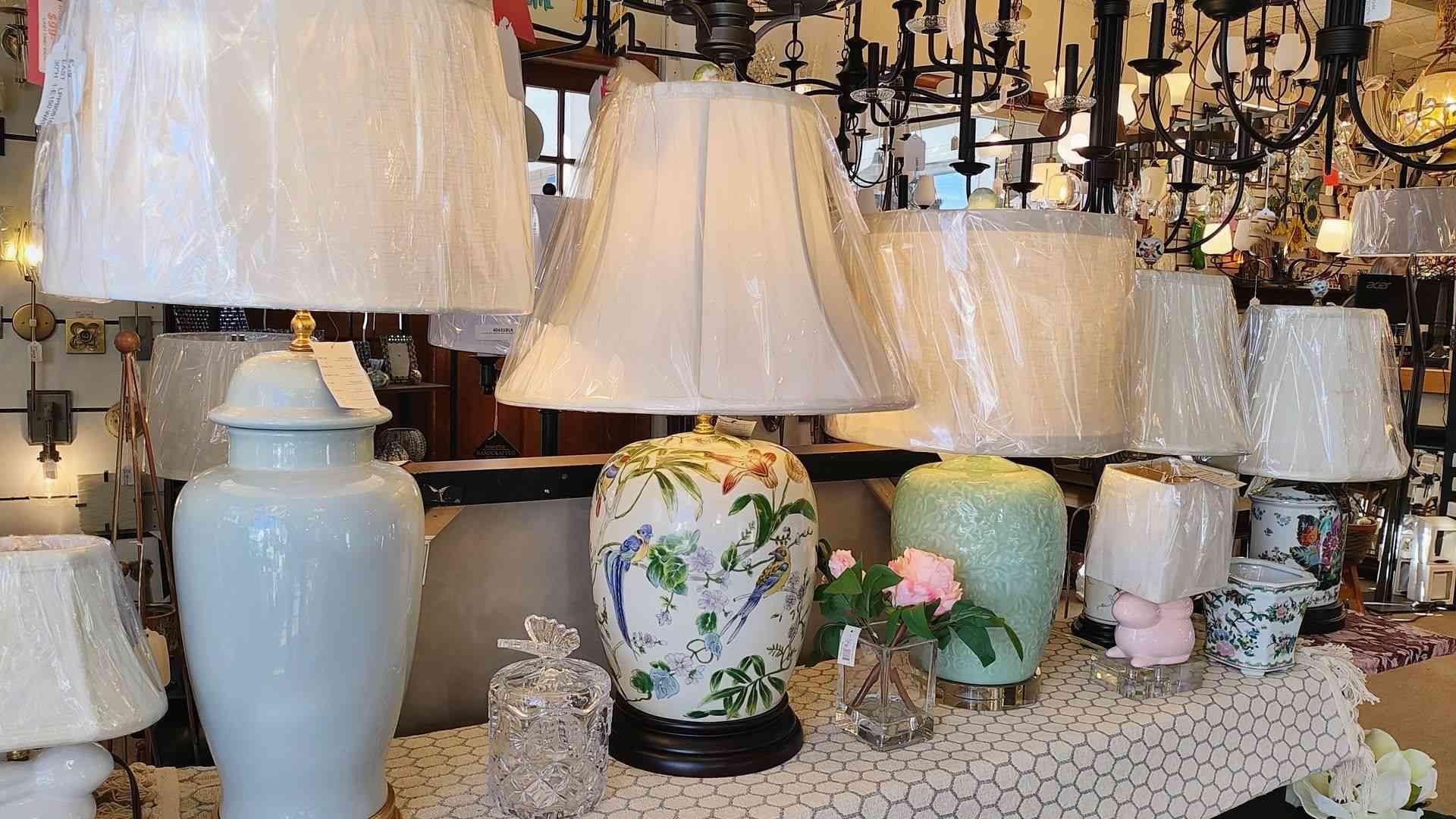 A bunch of lamps are sitting on a table in a room.