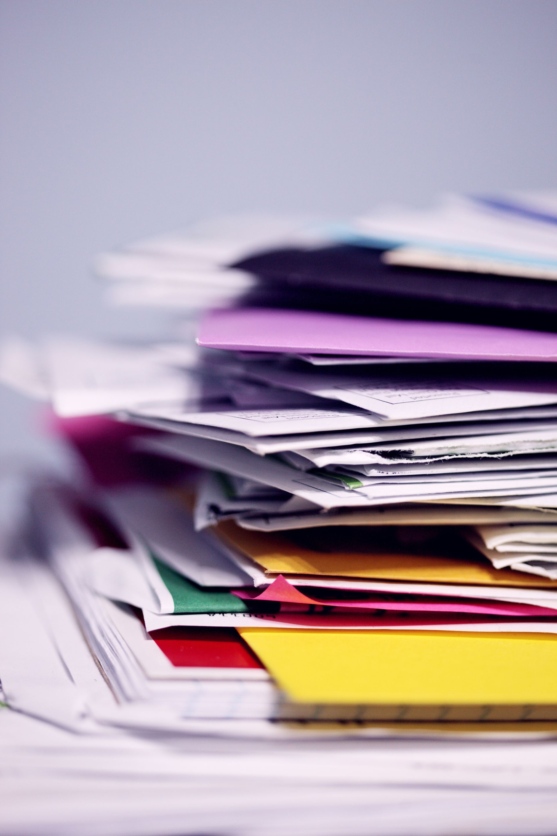 A stack of colorful envelopes and papers on a table