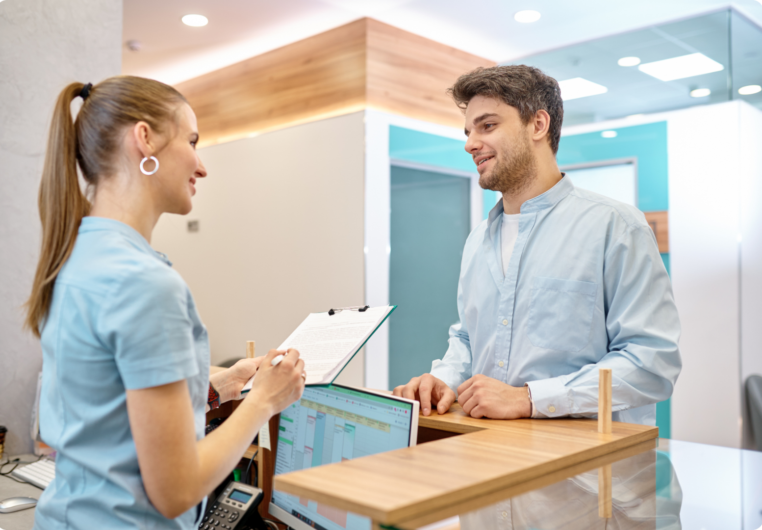 Un hombre está hablando con una enfermera en un consultorio dental.