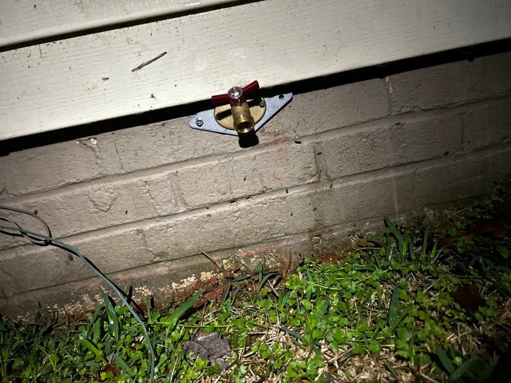 Outdoor faucet mounted on brick and siding.