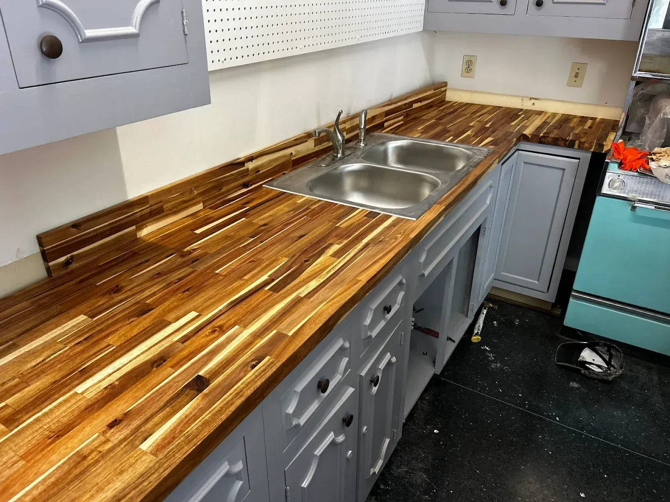 Kitchen with wooden countertops, a double sink, and gray cabinets.