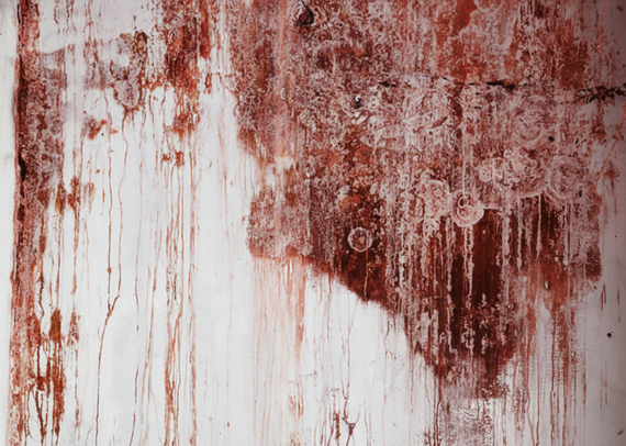 Red and white weathered wall with streaks and splotches.