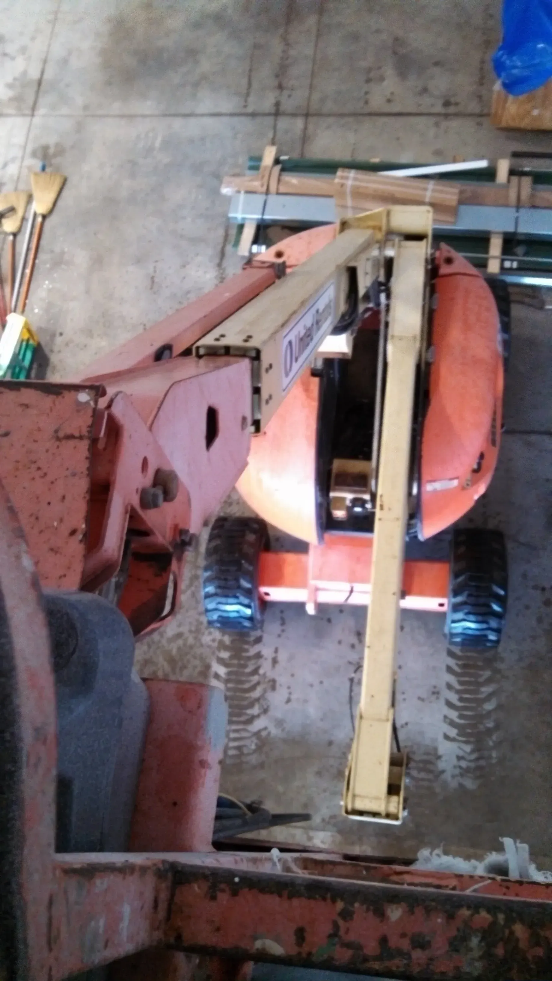 Orange and beige boom lift inside a warehouse.
