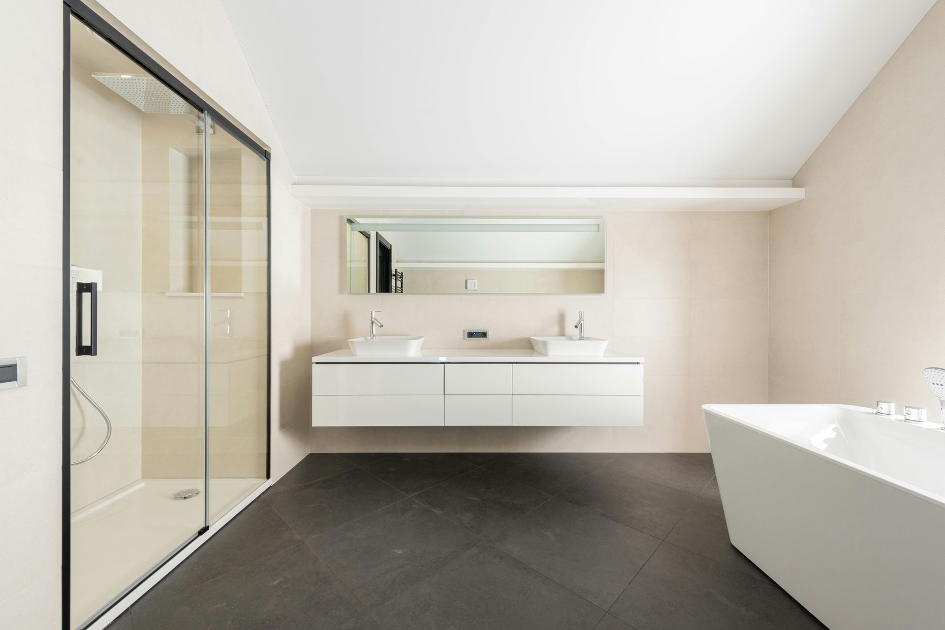 Modern bathroom with shower, floating vanity, and bathtub. Dark floor, beige walls, and white fixtures.
