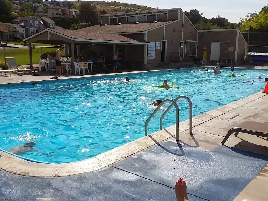 A group of people are swimming in a swimming pool.