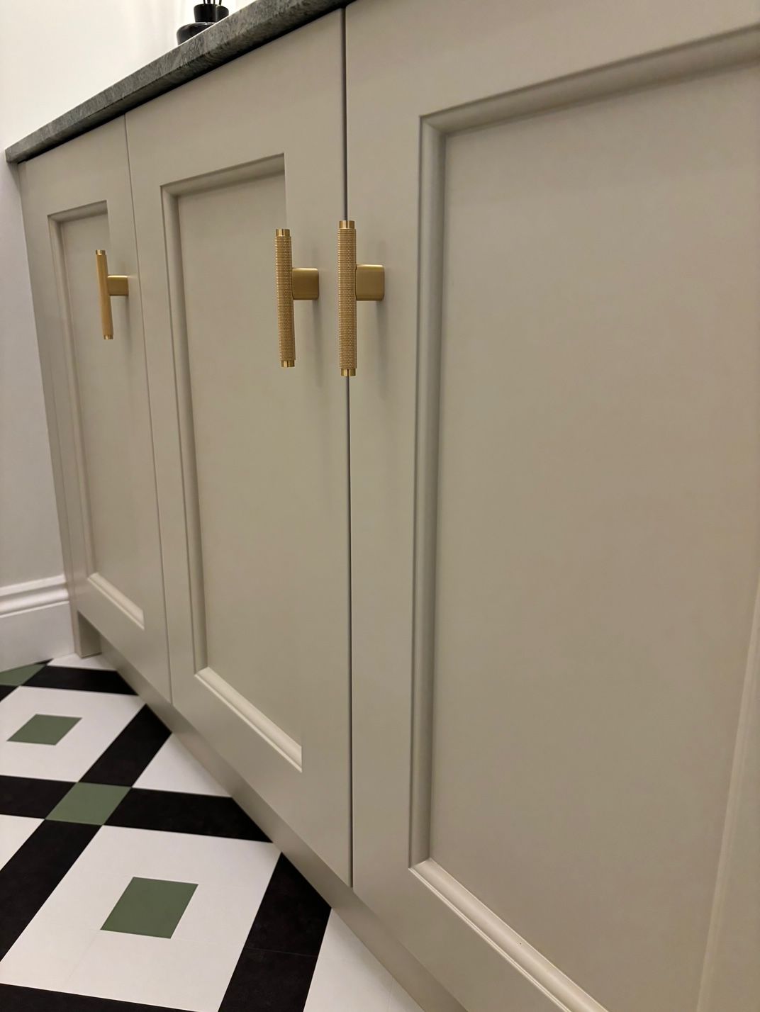 Hallway with light fixture, plant, staircase, and wooden door. Neutral colors.