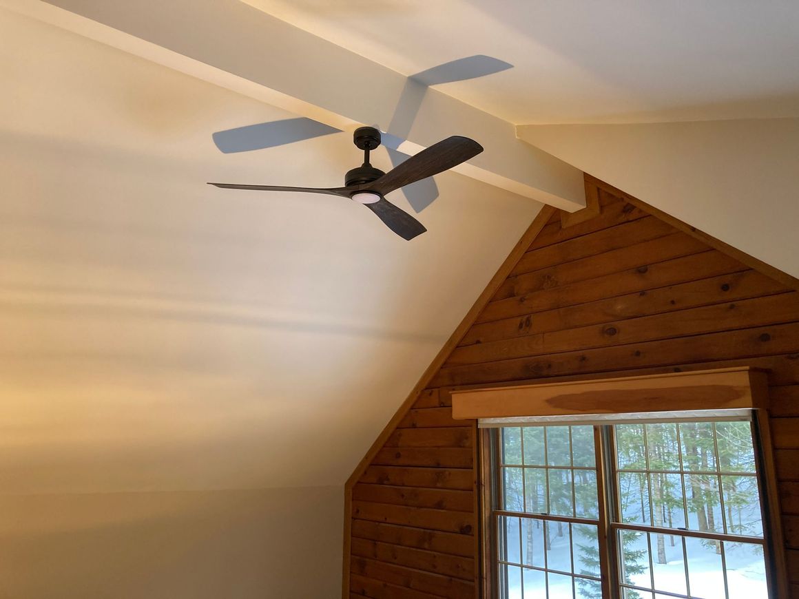 A room with a ceiling fan and a window