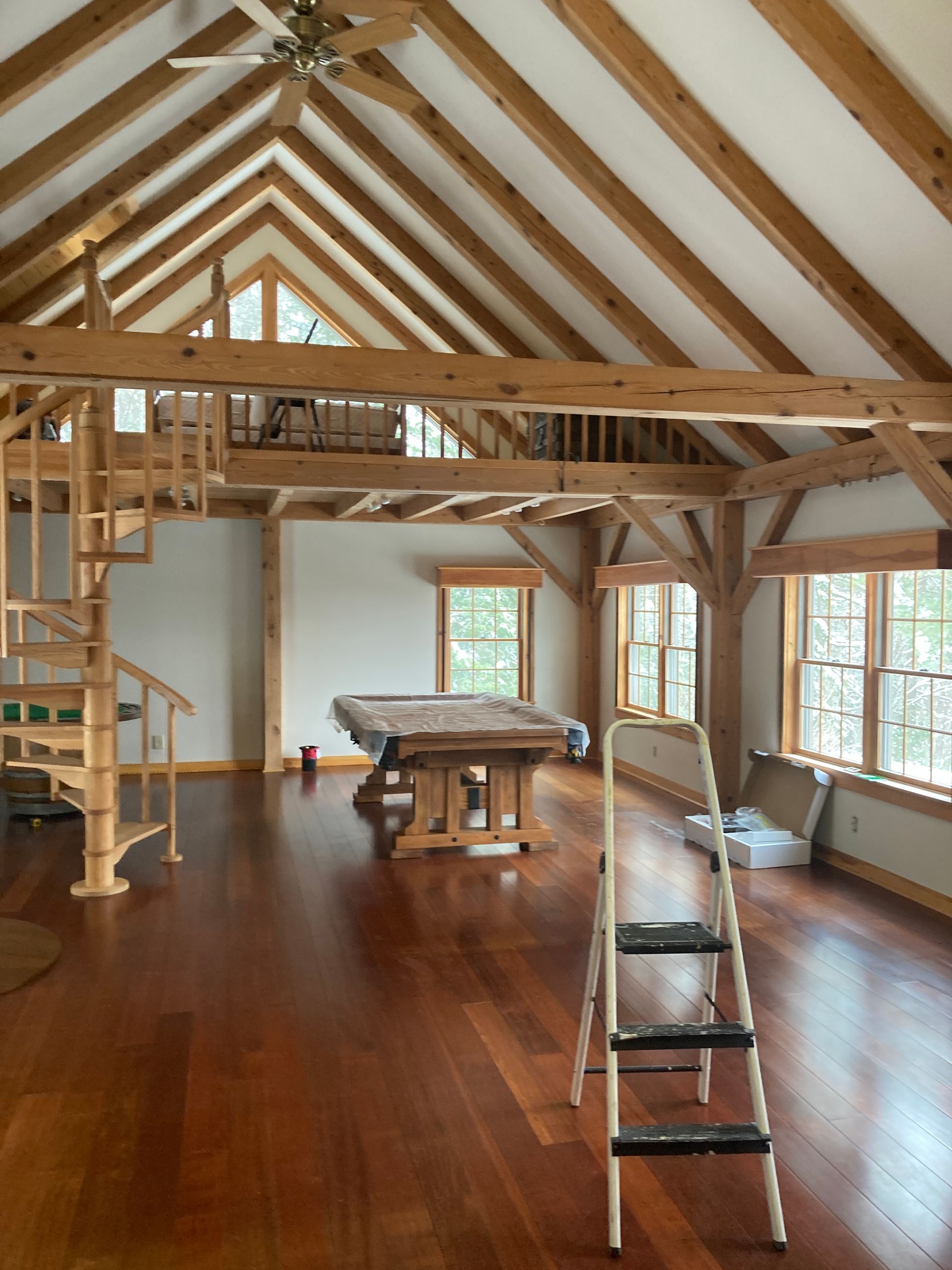 A large room with a pool table and a spiral staircase