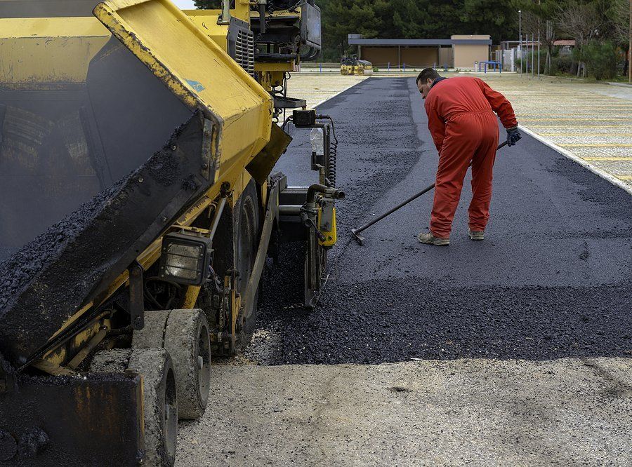 contractor spreading asphalt on road