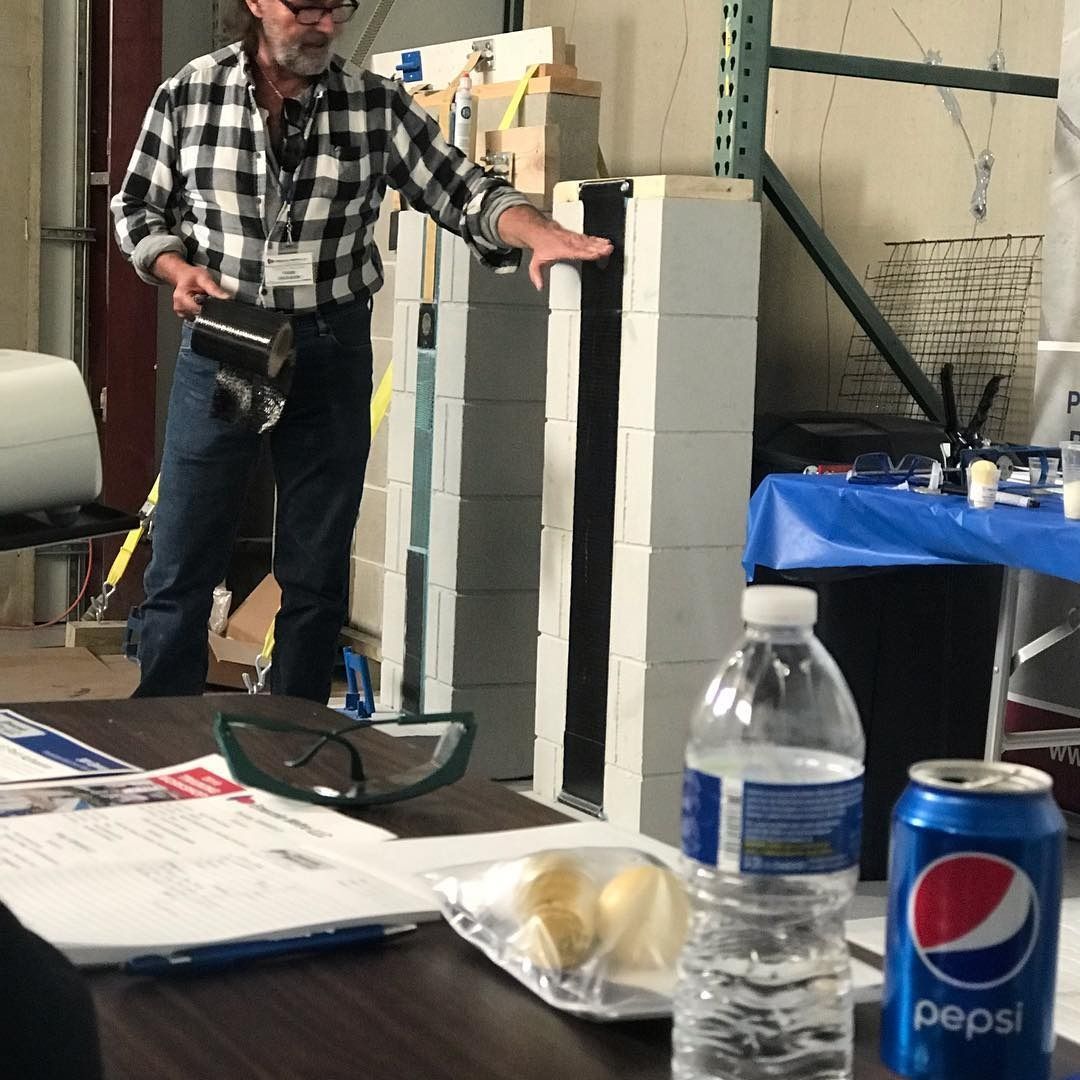Man demonstrating building materials. White and black blocks, Pepsi can, water bottle, and table.