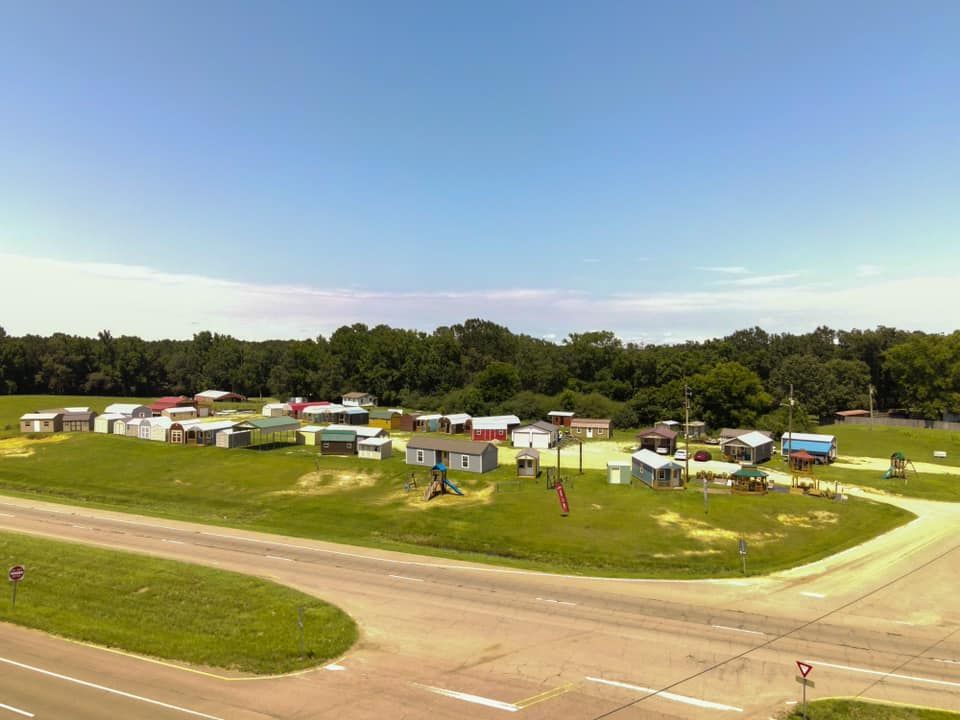 Aerial image of a Stor-Mor dealer lot next to a highway with variety of buildings, and marketing signage visible.