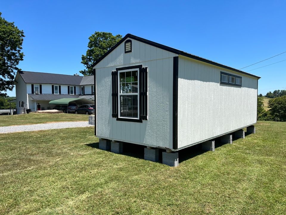 A small metal shed sits next to a body of water