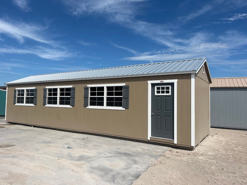 A small brown building with a gray door and windows