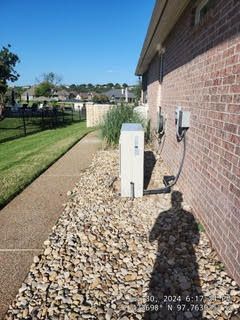 A brick house with a white box on the side of it.