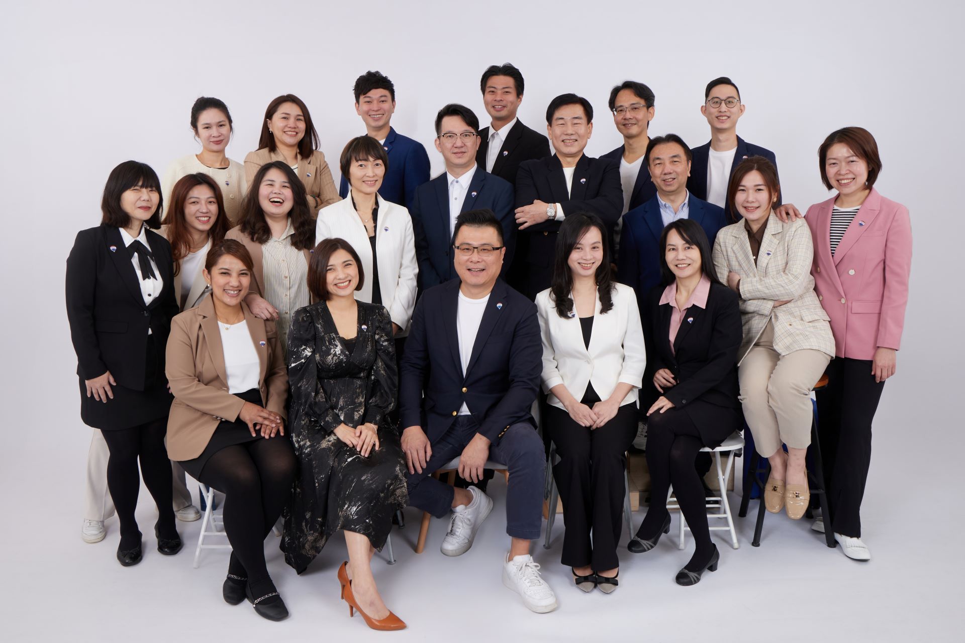 一群身著商務正裝的人在白色背景前合影。