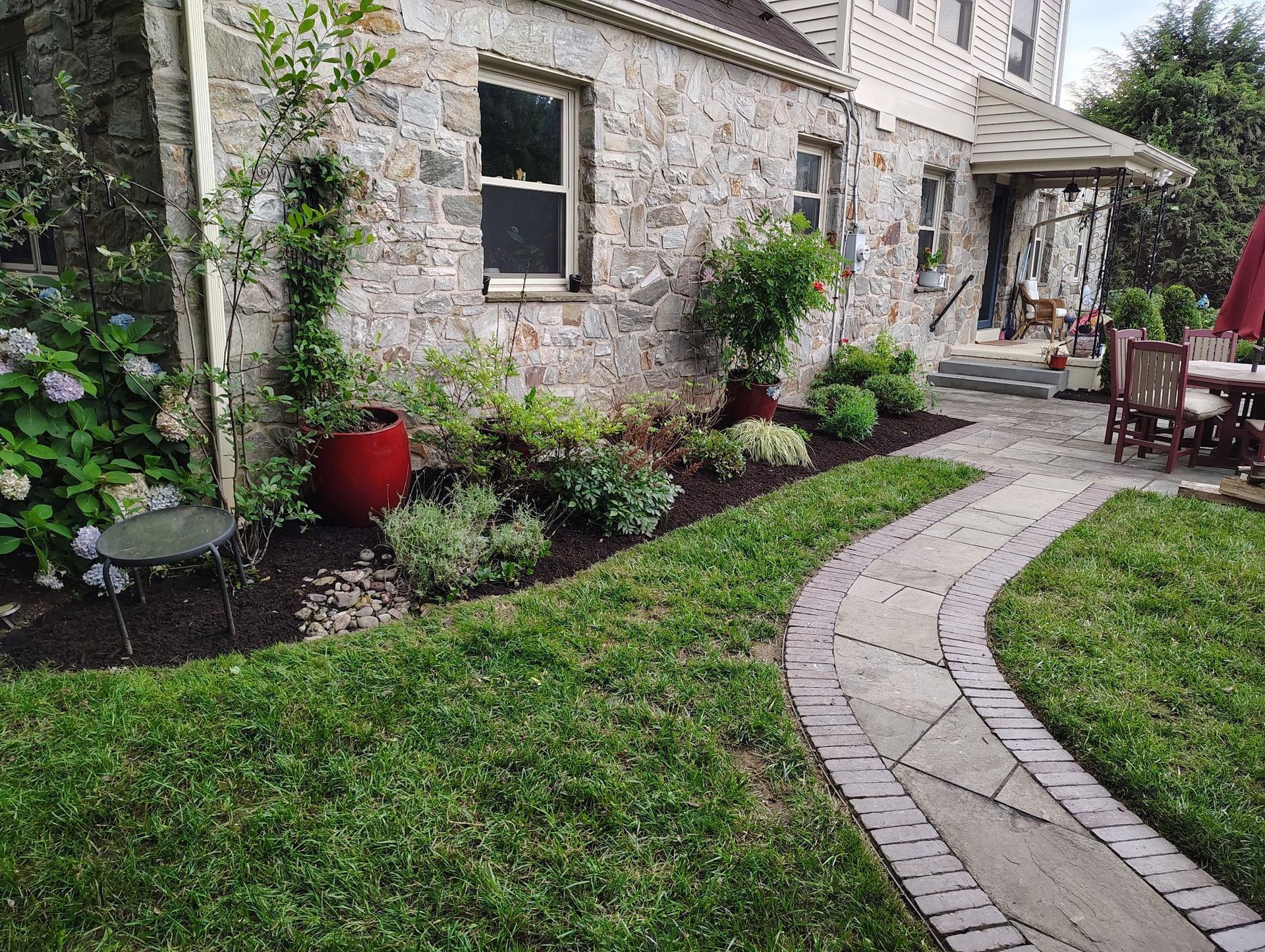 A brick walkway with a bush in the middle of it