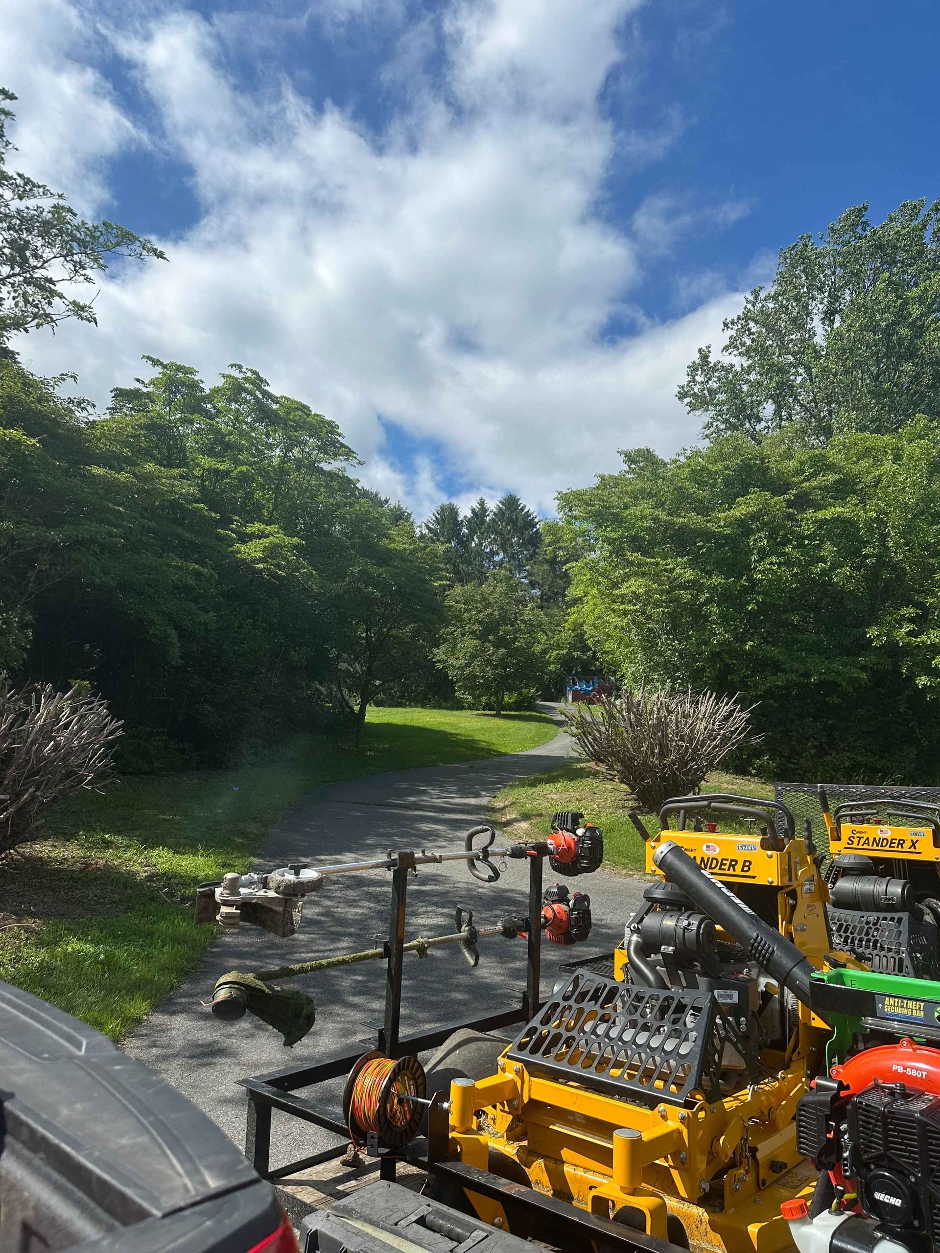 A yellow lawn mower is parked on the side of a road.