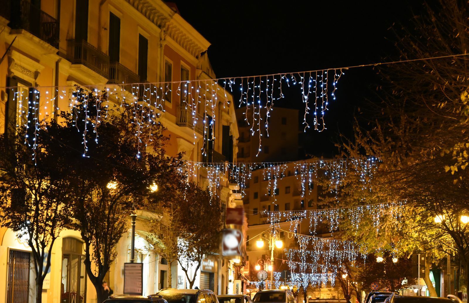 A city street at night with christmas lights 