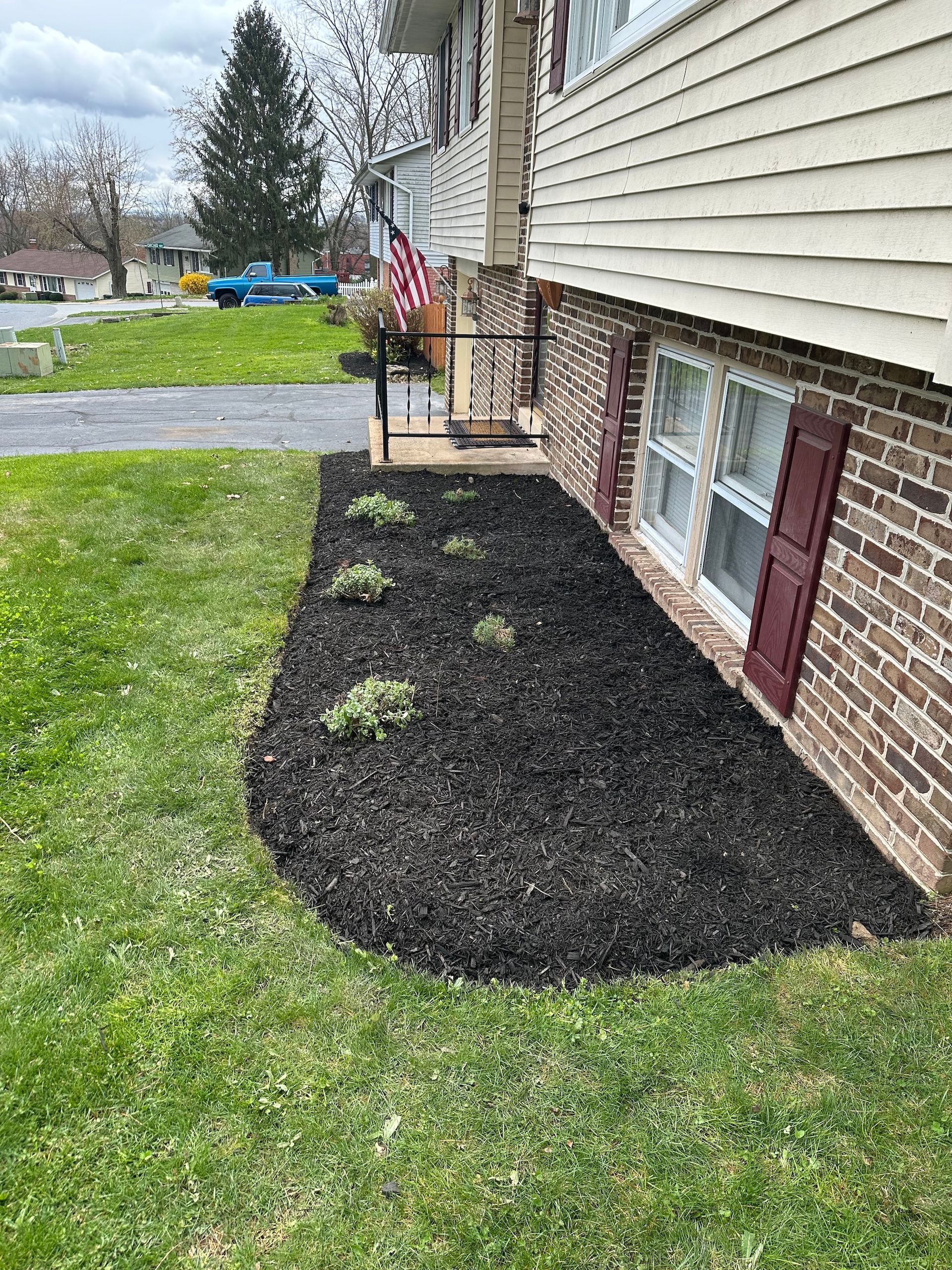 A brick house with a lush green lawn in front of it.