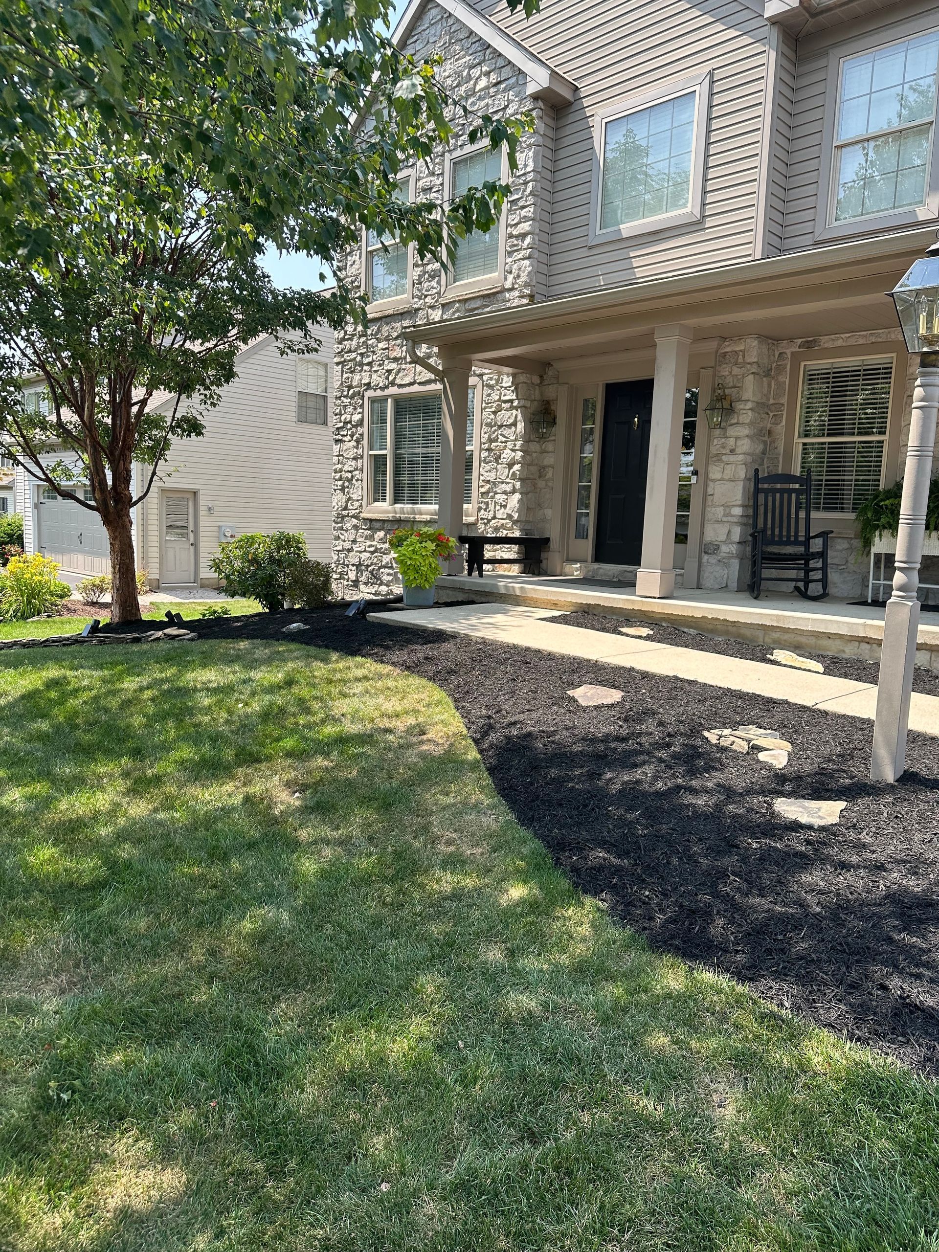 The front of a house with a large lawn and a porch.