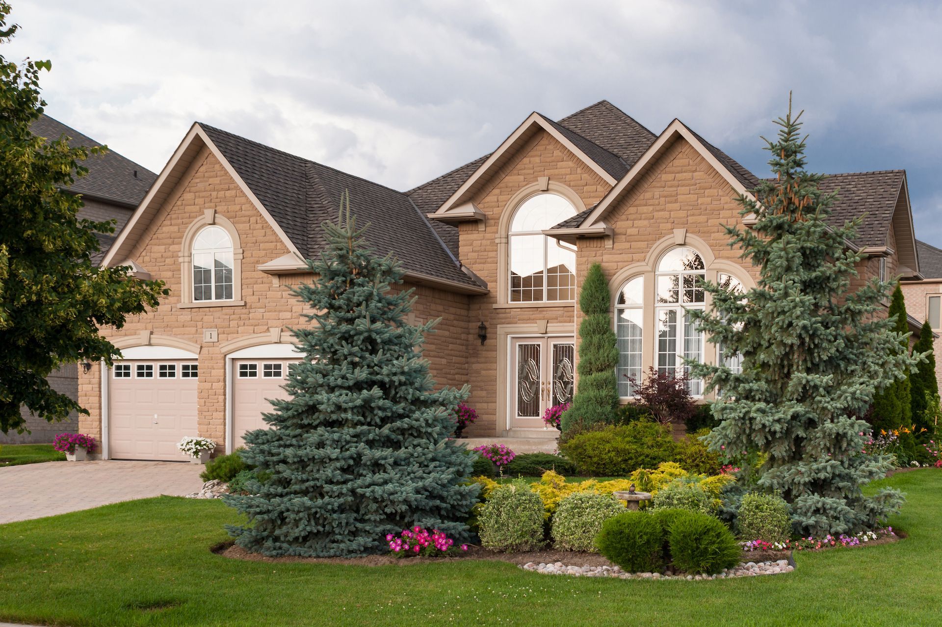 A large brick house with a lot of windows and trees in front of it
