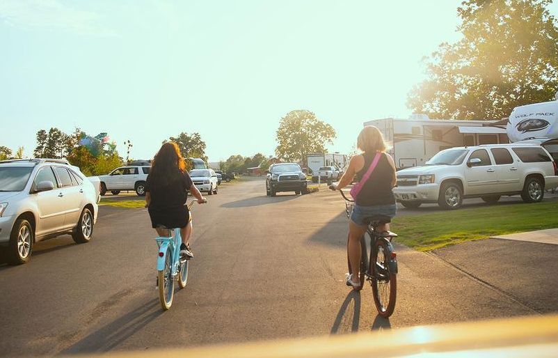 two women are riding bicycles down a street .
